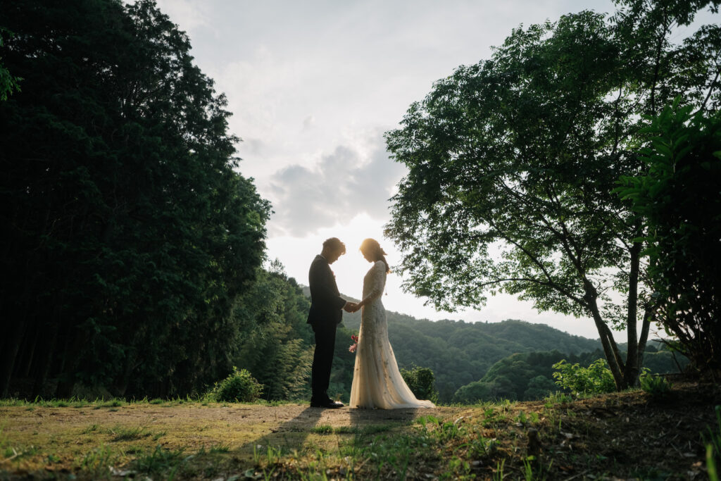 豊田市の自然に囲まれた結婚式場で、夕暮れの中ふたりが誓いを交わすシルエット写真